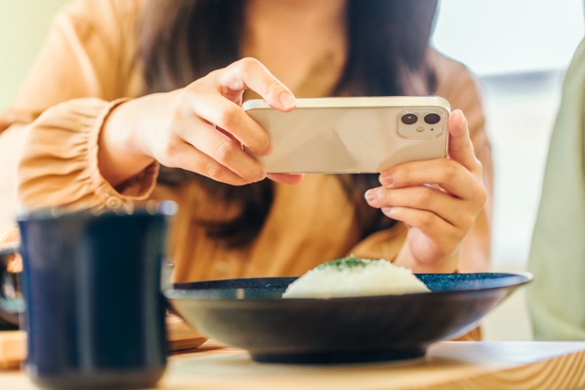 食べ物の写真を撮る女性